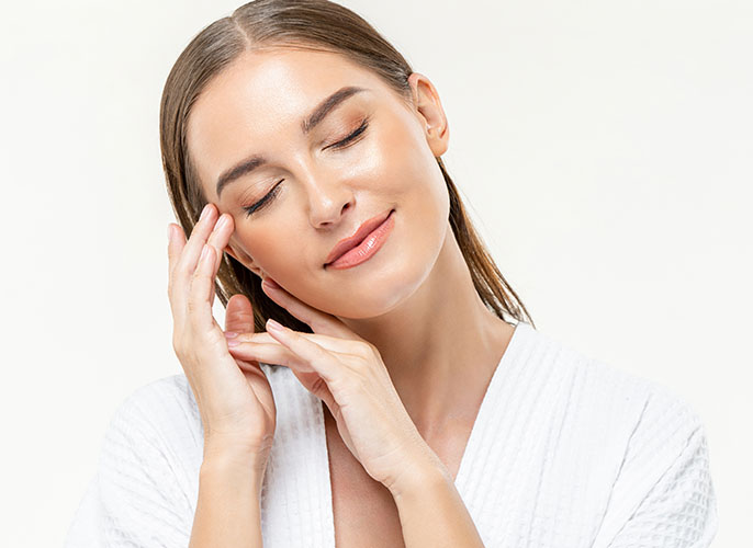 Woman with high key light posing with hands on her face