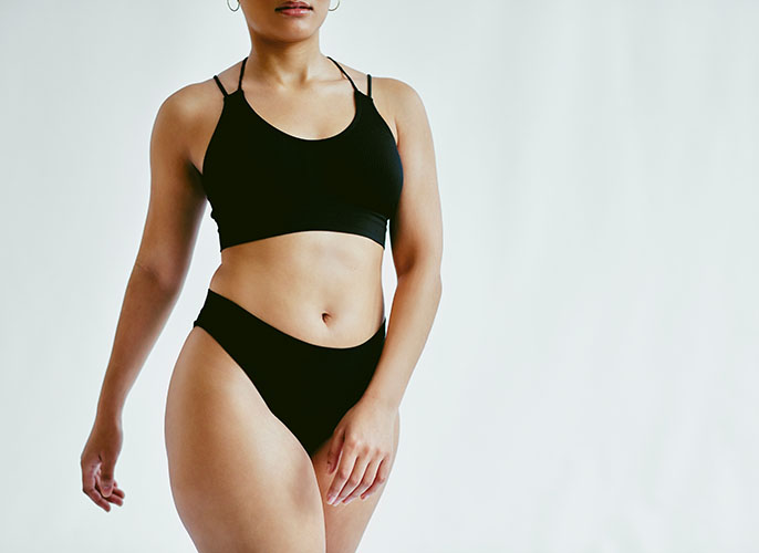 Woman walking in black sports bra and underwear