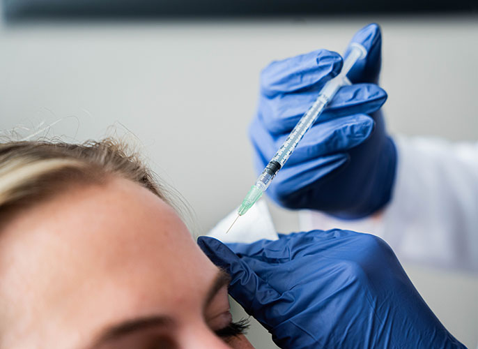 Surgical nurse at Advanced Plastic Surgery injecting a patient with BOTOX