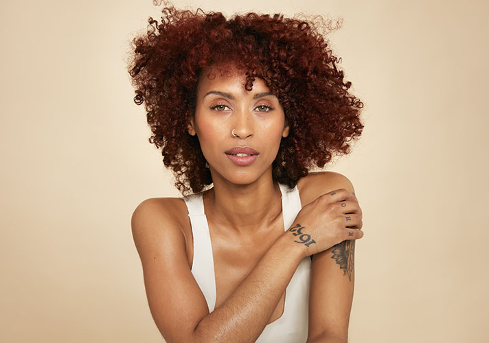 Curly haired woman with tattoos