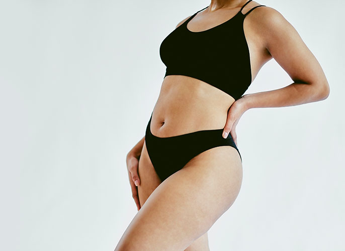 Showing woman's toned mid section wearing black sports underwear