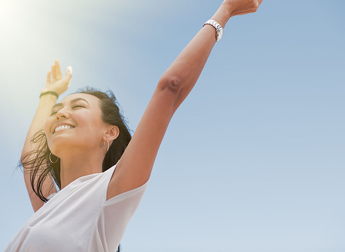 Woman with her hands up excited to be alive and healthy