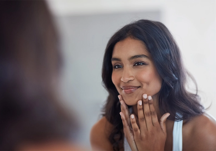 Woman looking at her reflection in a mirror
